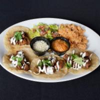 Taylor's Tacos · Served on crisped white corn tortillas, secret salsa, cilantro, Cotija cheese and lime.