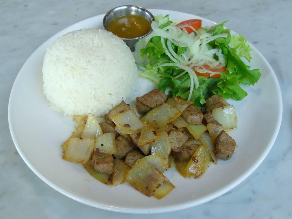 CM4. Com Bo Luc Lac · Stir-fried marinated tender beef cubes with yellow onions. Served with a small vinaigrette lettuce and tomato salad, steamed rice, and our house special honey mustard sauce on the side. 