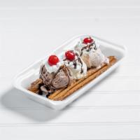 33. El Churro Split · 2 churros with 3 ice cream balls, whipped cream, chocolate syrup and cherries on top.