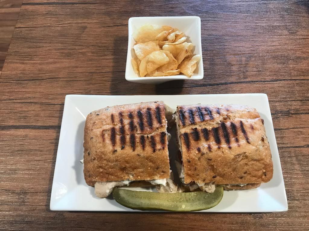 Aristotle's Greek Panini · Grilled chicken, feta cheese, cucumbers, tomatoes, onions, Greek Isles spice blend and your choice of tzatziki, spicy feta or Kalamata olive spread (shown on wholegrain ciabatta).