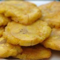 Tostones/ green plantains · Fried green plantains.
