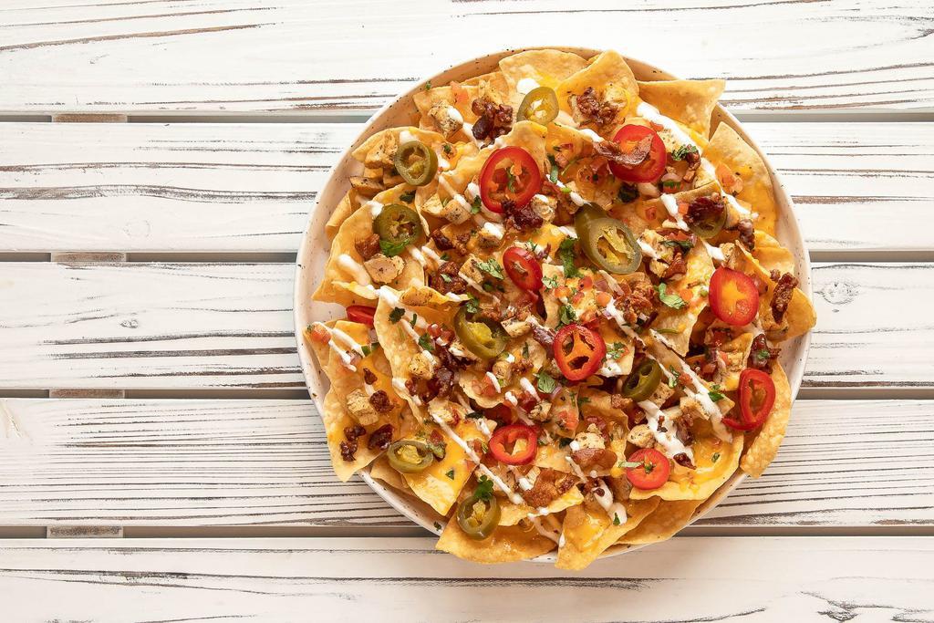 Tasty Nachos · Grilled chicken, tortilla chips, queso, pickled jalapeños, chopped bacon and pico de gallo.
