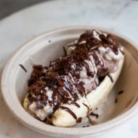 Banana Split · One banana face open, with three scoops of Neapolitan ice cream, whipped cream, crushed cone...