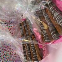 Chocolate-Dipped Pretzel Rods · Caramel wrapped pretzel dipped into milk chocolate and drizzled with white chocolate. Indivi...