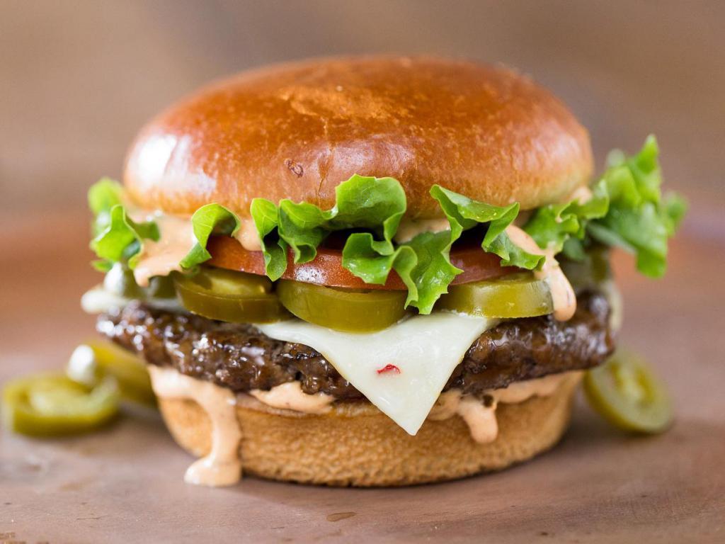 The Spicy Houston Burger · Spicy jalapenos, pepper jack cheese, crisp leaf lettuce, fresh tomato, and our smokin' chipotle ranch sauce. Served with choice of side.