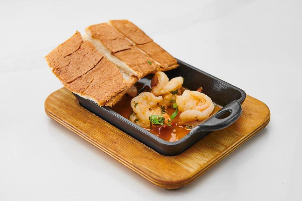 Camarones Al Ajillo · shrimps sautéed in a butter wine garlic sauce served with toast.