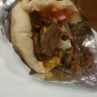 Shawarma Sandwich Beef · Beef shawarma shaved off the skewer packed ina pita with house salad and  sauce.