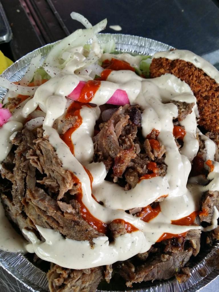 Shawarma Platter · Thinly sliced beef and lamb marinated in our secret spice blend, stacked and roasted to perfection. served over rice and salad