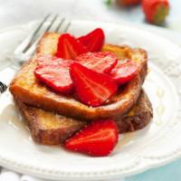Strawberry French Toast · Sliced challah bread soaked in eggs and milk, then fried and topped with strawberries.