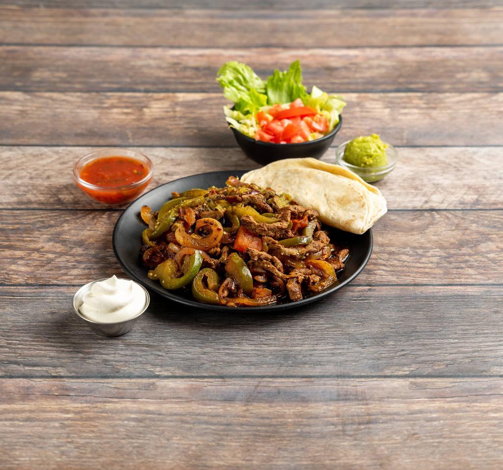 Beef Fajitas · Served with rice, refried beans, lettuce, guacamole, sour cream, pico de gallo and flour tortillas, fajitas are marinated in our special recipe. Delivered hot on a bed of tomatoes, onions, and green peppers.