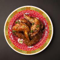 Mo Wangs · Caramelized natural Bell and Evans wings tossed in fish sauce and garlic topped with sesame ...