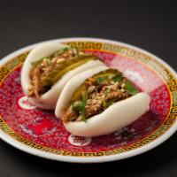 Pork Bao · Spiced honey pulled pork with pickles, topped with cilantro and peanuts.
