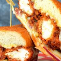 Nashville Po’Boy · Crispy Nashville hot chicken tenders pressed in a French roll with Monterey jack cheese, dil...