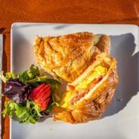 The Boss Egg Sandwich · 2 farm fresh eggs on a  toasted butter croissant with bacon, ham, tomato, white cheddar chee...