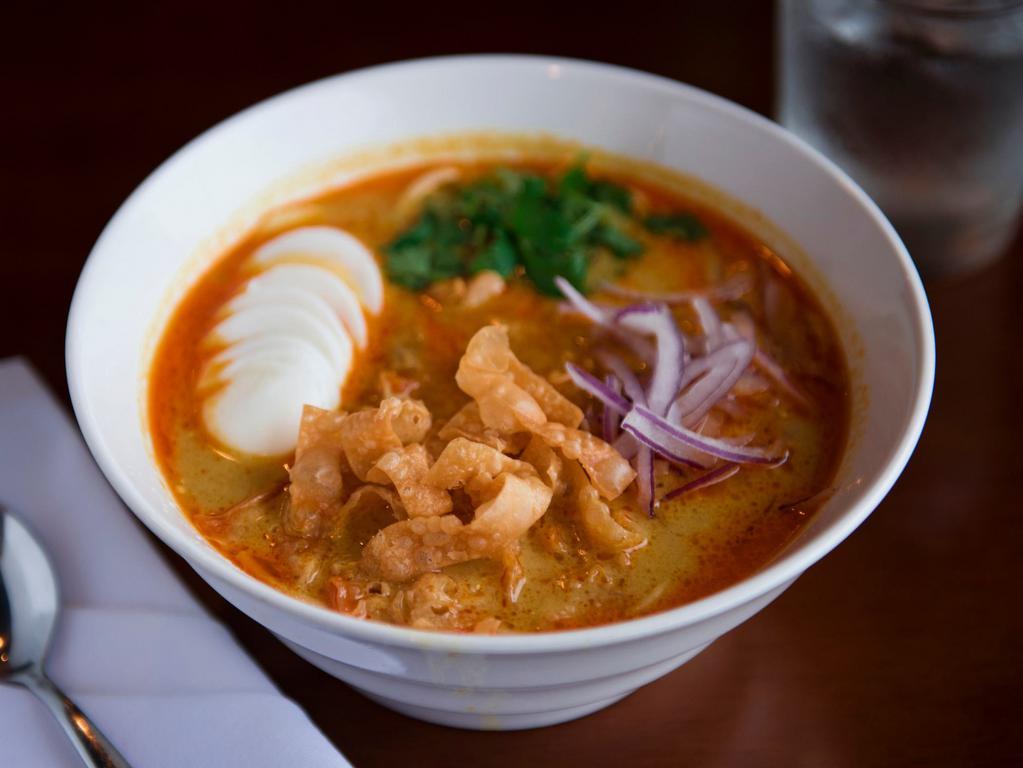 Coconut Chicken Noodle Soup · Rich in coconut milk soup served with chicken, egg noodles, hard boiled-egg cilantros, fresh red onions and wonton chips.
