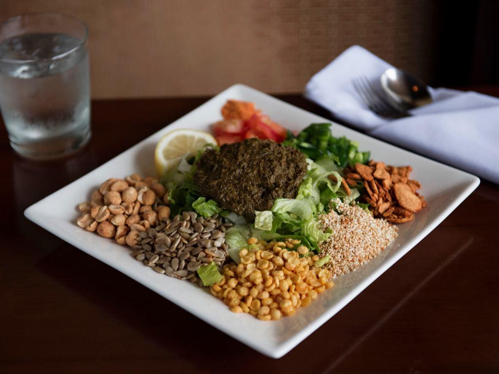 Tea Leaf Salad · Burmese fermented tea leaves serves with lettuce, tomatoes, jalapenos, peanuts, garlic chips, fried yellow beans, sesame seeds, sunflower seeds and dried shrimp powder.