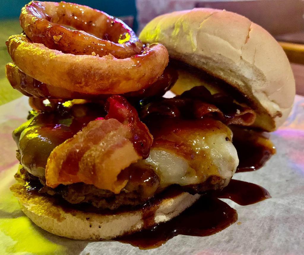 Cowboy Burger · Pepper jack cheese, bacon, onion rings, BBQ and toasted bun. 