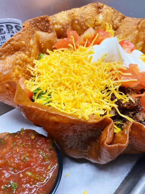 Taco Salad · Fried tortilla shell, lettuce, ground beef, cheddar cheese, tomatoes, sour cream and salsa.