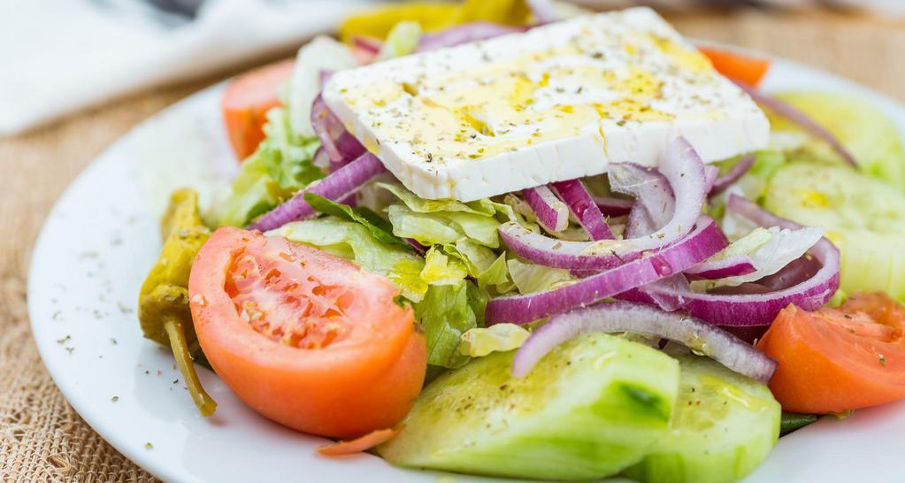 Greek Salad · Tomatoes, cucumbers, pepperoncinis, Kalamata olives, red onions and feta on a bed of lettuce.
