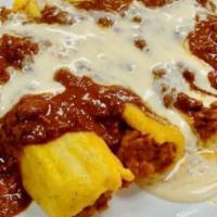 Tamales · Tamales topped with chili and queso.
