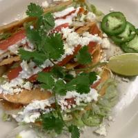 Crispy tinga tacos  · Chipotle tomato chicken served with crispy corn shells  toped with letters tomato sour cream...