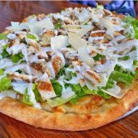 Chicken Caesar Pizza  · Topped with romaine lettuce, grilled chicken, creamy Caesar dressing, and grated Parmesan. 