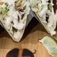 Blackened Fish Tacos · Topped with cilantro lime slaw and malt vinegar aioli, served in warm corn tortillas.