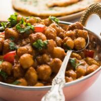 Puri Cholay · Hearty garbanzo bean curry topped onto veggie samosas. Vegan.