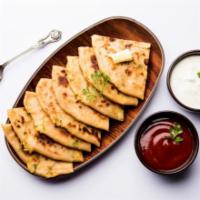 Aloo Paratha · Flat bread stuffed with tender potatoes served with a side of yogurt. Vegan.