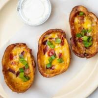 Potato Skins · potato skins served with sheered cheese, bacon, green onions and 2oz of ranch on the side