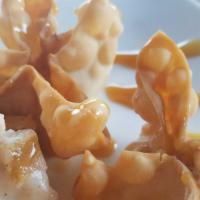 Apple Cheesecake Wontons · 8 in an order with a caramel drizzle on top.