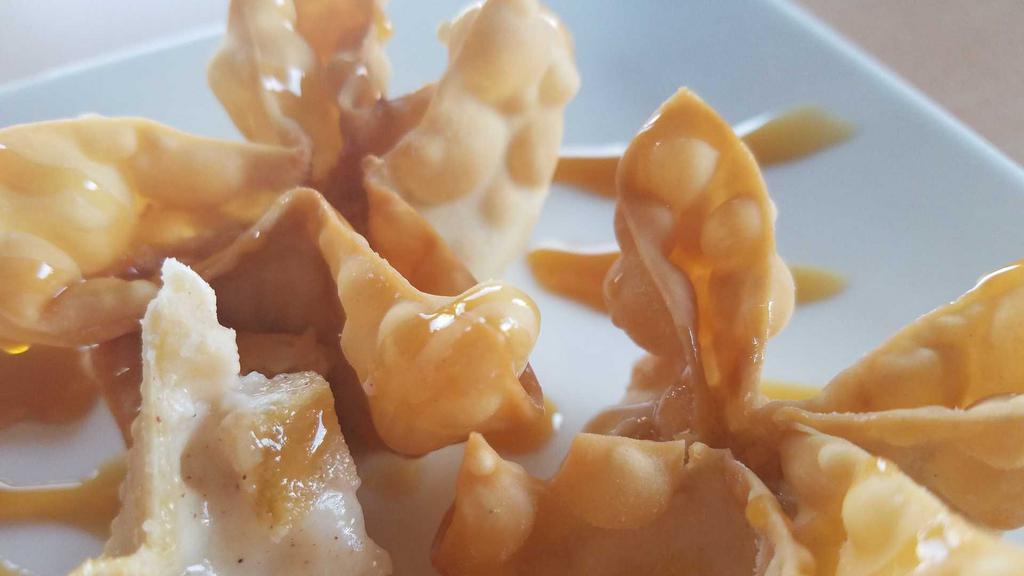 Apple Cheesecake Wontons · 8 in an order with a caramel drizzle on top.