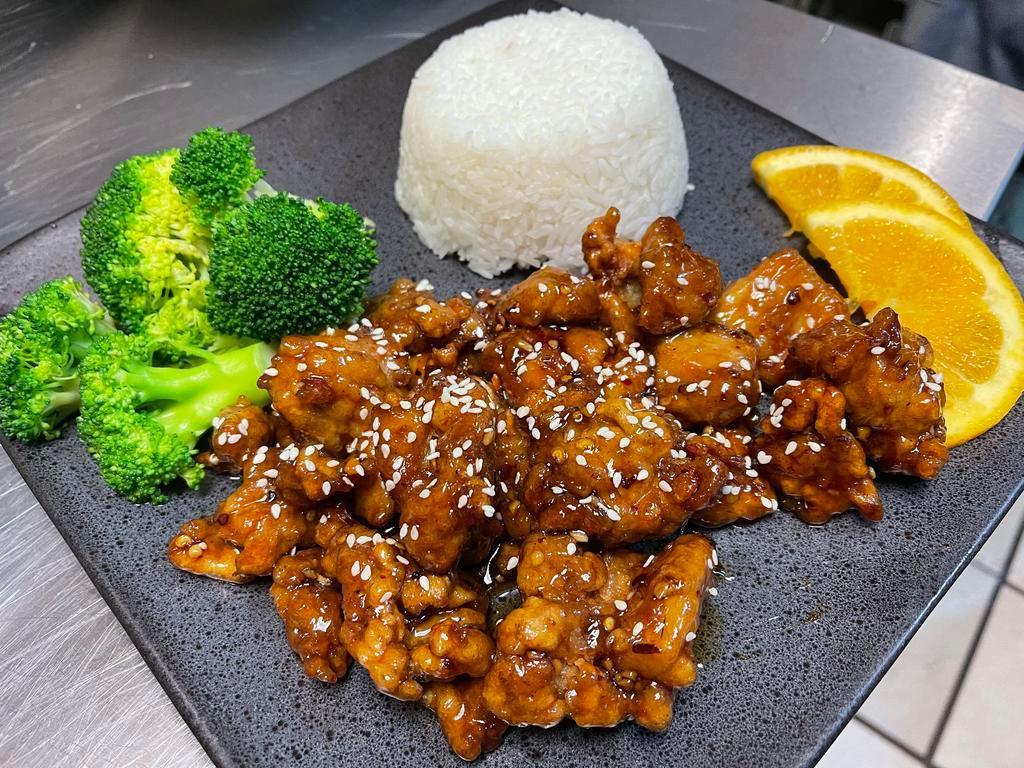 Orange Chicken · Fried and crispy pieces of chicken covered in authentic tangy orange sauce that is sweet and salty served with steamed broccoli and steamed jasmine rice.