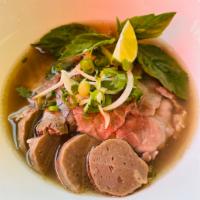 Beef Pho · Served in a bowl with a specific cut of flat rice noodles in clear richly Vietnamese Style b...