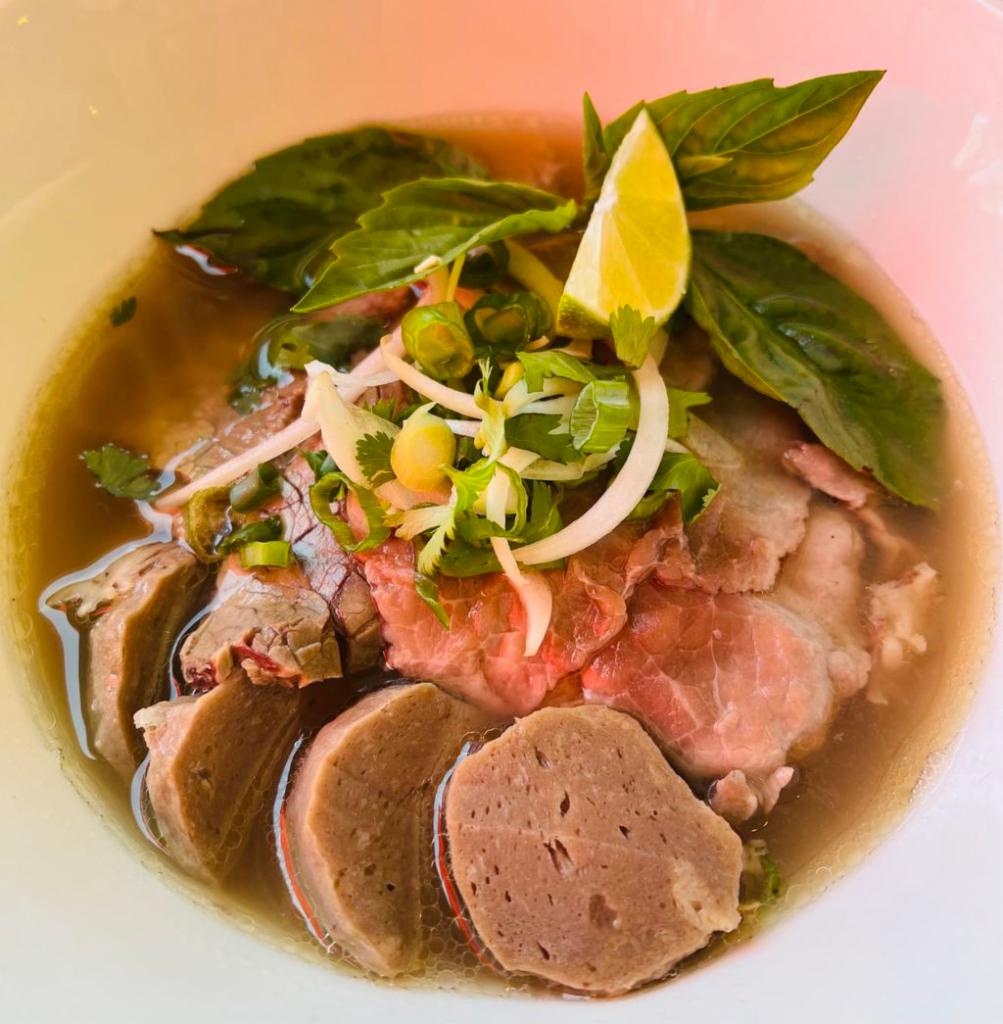 Beef Pho · Served in a bowl with a specific cut of flat rice noodles in clear richly Vietnamese Style beef broth, with thin cuts of beef, a side of bean sprouts with lime wedges, jalapeños and Asian basils. 
