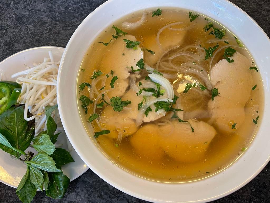 Chicken Pho · Served in a bowl with a specific cut of flat rice noodles in richly Vietnamese Style chicken broth, with sliced chicken breast, a side of bean sprouts with lime wedges, jalapeños and Asian basils. 
