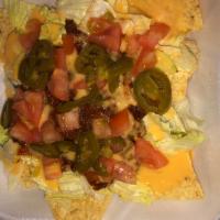 Taco Salad · A bed of tortilla chips with seasoned ground beef and cheese. Served with lettuce, tomatoes,...