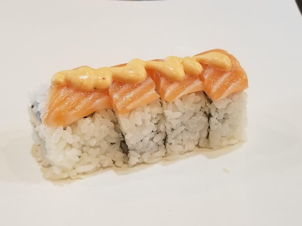 New York Roll  · 4 pieces. Crab salad, cream cheese, topped with salmon, spicy mayo and masago. Raw.
