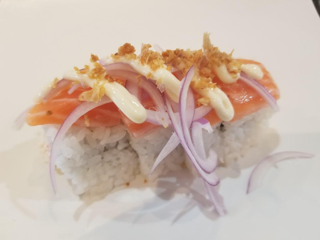 Tokyo Roll · 4 pieces. Crab salad topped with fresh salmon, red onions, fried garlic flakes, and mayo. Raw.