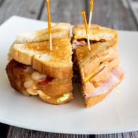 Classic Club Sandwich · Roasted turkey, sliced ham, bacon, and American cheese served on toasted white bread with le...