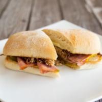 Cuban Sandwich · Roasted pulled pork topped with sliced ham, Swiss cheese, pickle, and mustard served on a pr...