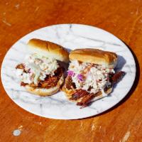 Pulled Pork Sandwich · Two pulled pork sandwiches with cole slaw and your choice of one mustard potato salad or one...