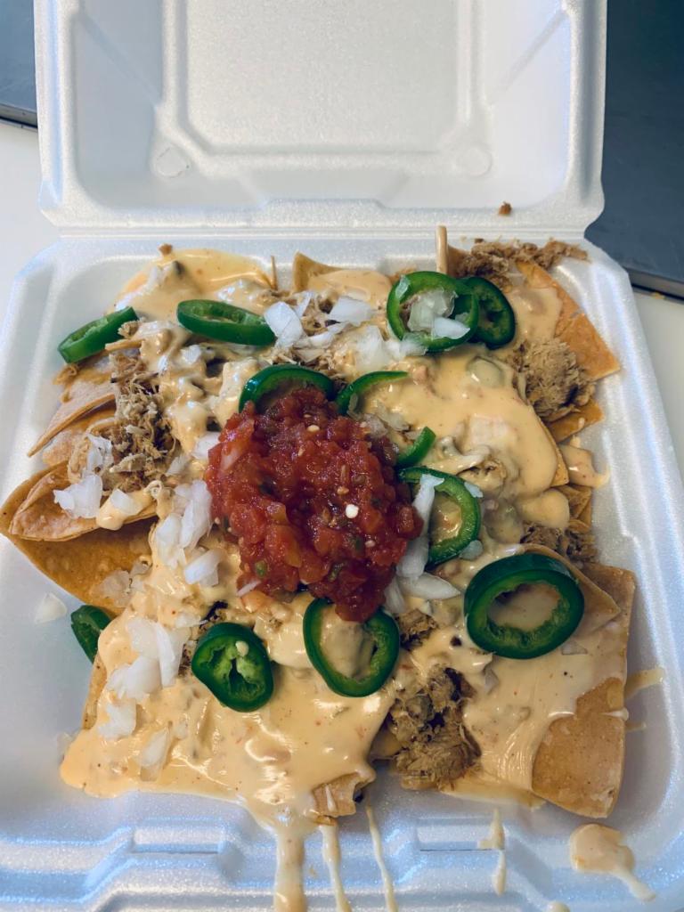Pit-stop Nachos · Choice of meat, queso, jalapeños, onions and salsa loaded on a bed of fresh corn tortilla chips.