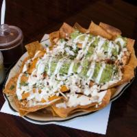 Nachos Texanos · Chips with beans, guacamole, cheese, onions, cilantro and sour cream with choice of meat.