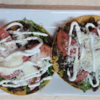tostadas steak (2) · Fried corn tortilla, topped W smashed beans, lettuce, tomato, cotija, cheese, and sour cream.
