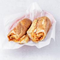 Chicken Cutlet Parmigiana Hero · A long sandwich on a roll with thinly sliced breaded chicken, tomato sauce and cheese.