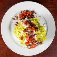 Wedge Salad · Served with crisp iceberg, bacon, red onions, tomatoes & crumbled bleu cheese.
