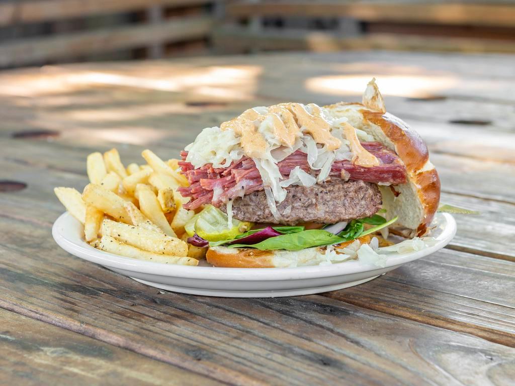 The Blarney Burger · Monolithic 1/2 lb. burger with corned beef, kraut, Swiss, Dullahan Island dressing, mixed greens, onions, tomato, pickles on a pretzel bun.
