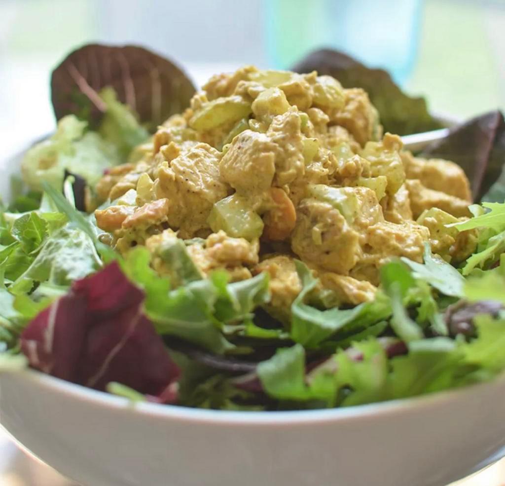 Curry Chicken Salad · Caribbean style curried chicken. Served on a bed of spinach and romaine lettuce garnished with tomatoes, sauteed onions, green onions 