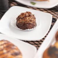 Macaroon · A baked hemisphere of Coconut shavings glazed in dark chocolate